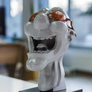 3D print of head painted grey with brown accents and a stone base